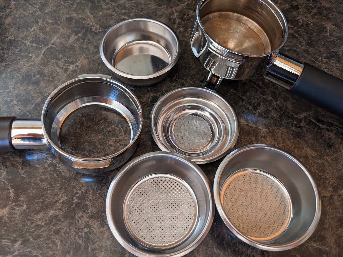 A portafilter with its basket beside it on a counter
