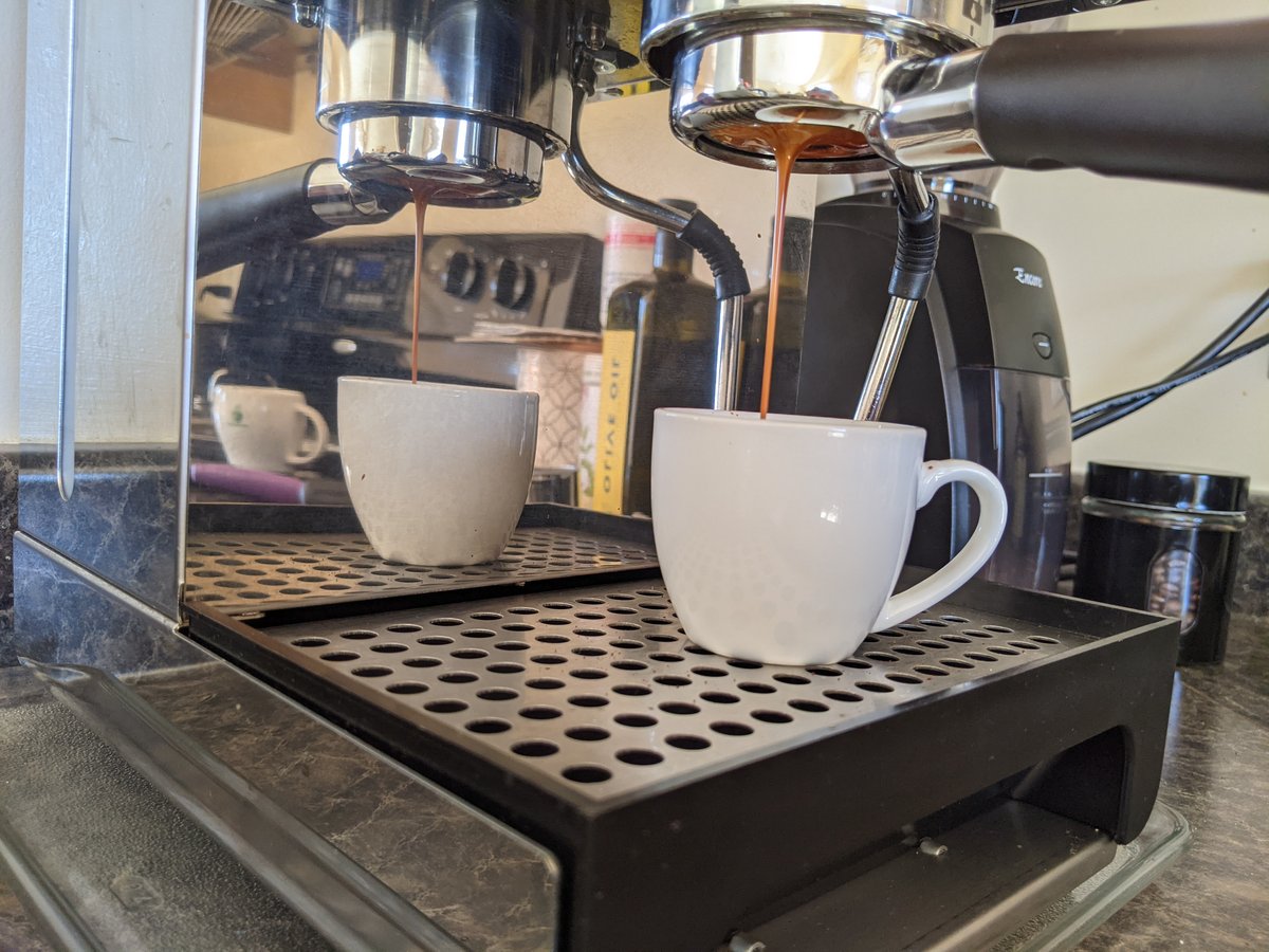 Espresso extracting from a bottomless portafilter into a cup on a scale